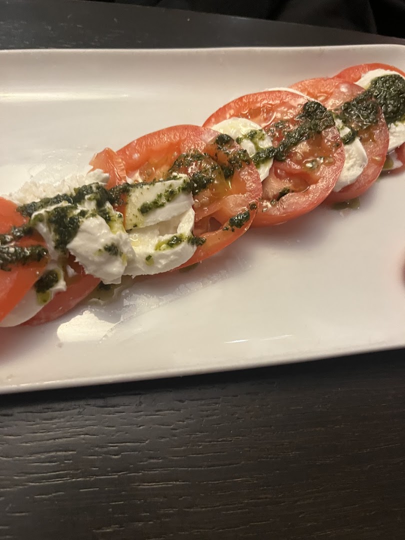 Des tomates avec fromage frais et sauce au basilic